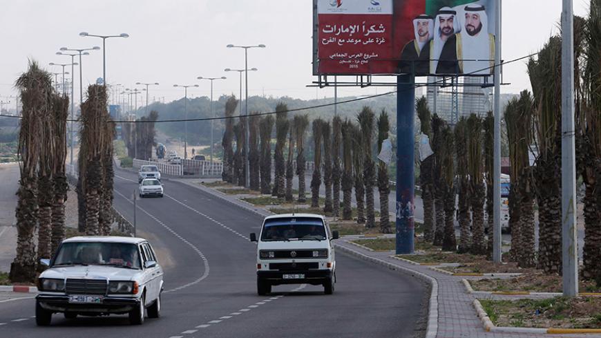 Palestinians drive past a billboard with pictures depicting UAE President Sheikh Khalifa bin Zayed al-Nahayan (R), Abu Dhabi Crown Prince Sheikh Mohammed bin Zayed (C) and UAE Deputy Prime Minister Sheikh Mansour bin Zayed al-Nahyan in Gaza City March 15, 2015. The billboard reads, "Thanks Emirates. Gaza is on a date for celebration. Mass wedding project." 
REUTERS/Ibraheem Abu Mustafa (GAZA - Tags: SOCIETY POLITICS) - RTR4TEDA