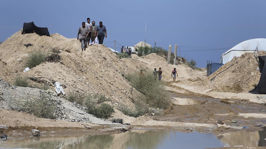 Palestinians inspect the damage after Egyptian forces flooded smuggling tunnels dug beneath the Gaza-Egypt border, in Rafah in the southern Gaza Strip September 18, 2015. According to Palestinian witnesses, the Egyptian authorities pumped water from the Mediterranean Sea through pipes to destroy the tunnels. REUTERS/Ibraheem Abu Mustafa - RTS1R6D