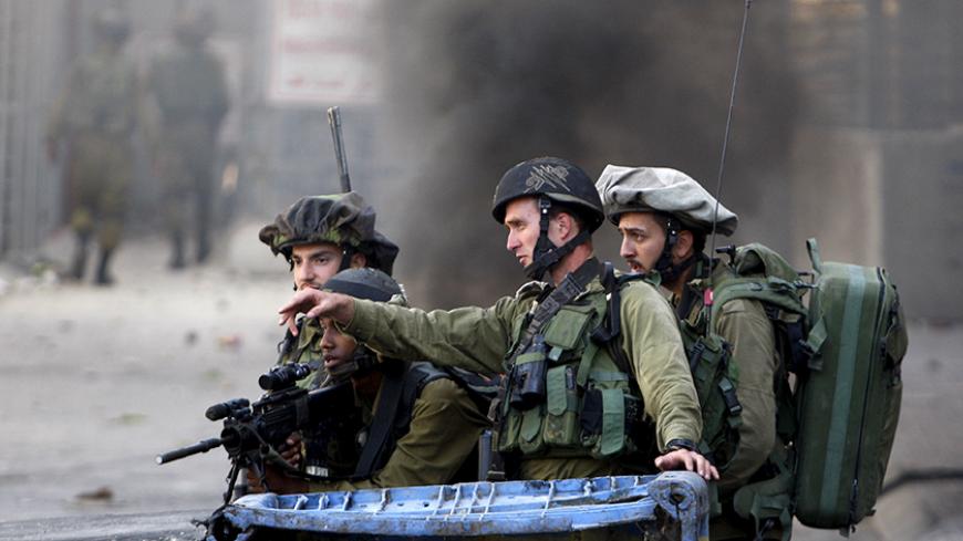 Israeli soldiers take position during clashes with Palestinian protesters in the occupied West Bank city of Hebron October 4, 2015. Israeli Prime Minister Benjamin Netanyahu's office said he would meet security chiefs later on Sunday to discuss more action to tackle a rising wave of violence in East Jerusalem, which includes the Old City, and the West Bank, areas that Israel captured in a 1967 war. REUTERS/Mussa Qawasma - RTS2YR1