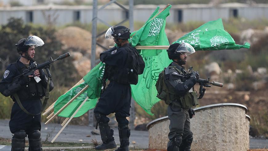 Israeli policemen confiscate Hamas flags during clashes with Palestinians near the Jewish settlement of Bet El, near the West Bank city of Ramallah October 8, 2015. Four people, including an Israeli soldier, were stabbed and wounded near a military headquarters in Tel Aviv on Thursday, police and ambulance sources said, as a rash of such Palestinian attacks spread to Israel's commercial capital. REUTERS/Mohamad Torokman - RTS3LE4