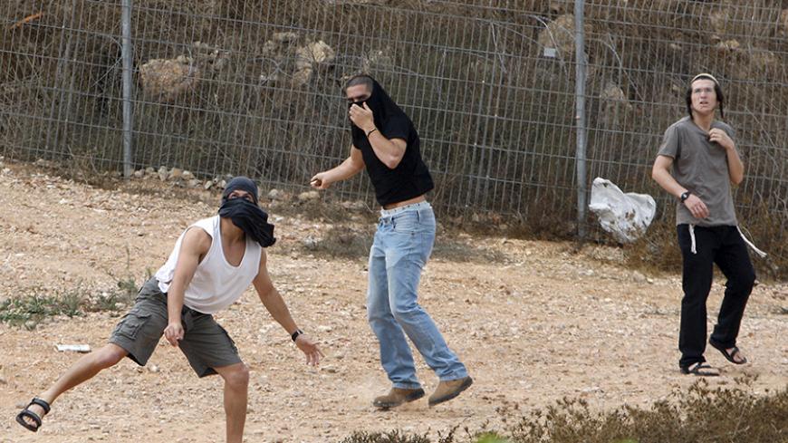 Israeli settlers throw stones at Palestinian houses (not seen) in the West Bank city of Hebron October 9, 2015. Four Arabs were stabbed in a town in southern Israel on Friday and a Jewish suspect was arrested, police said. The attacks follow a surge in knife violence by Palestinians against Israelis. REUTERS/Mussa Qawasma - RTS3PRD