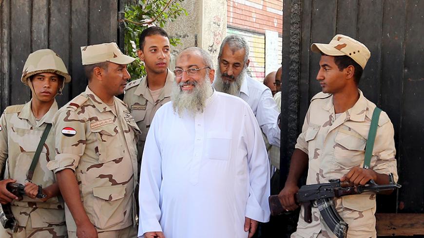 Security forces stand guard as Salafist cleric leader Yasser Borhamy leaves a school used as voting centr after he was casting his vote, in Alexandria, Egypt, October 18, 2015. Egypt kicked off a long-awaited parliamentary election on Sunday, the final step in a process that was meant to put the country back on a democratic course but which critics say has been undermined by state repression. REUTERS/Asmaa Waguih - RTS4YZI