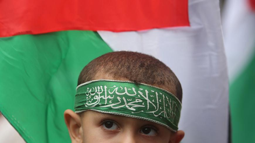A Palestinian boy wears a Hamas headband during an anti Israel rally, in the central Gaza Strip October 23, 2015. Palestinian factions called for mass rallies against Israel in the occupied West Bank and East Jerusalem in a "day of rage" on Friday, as world and regional powers pressed on with talks to try to end more than three weeks of bloodshed. REUTERS/Ibraheem Abu Mustafa - RTS5SBH
