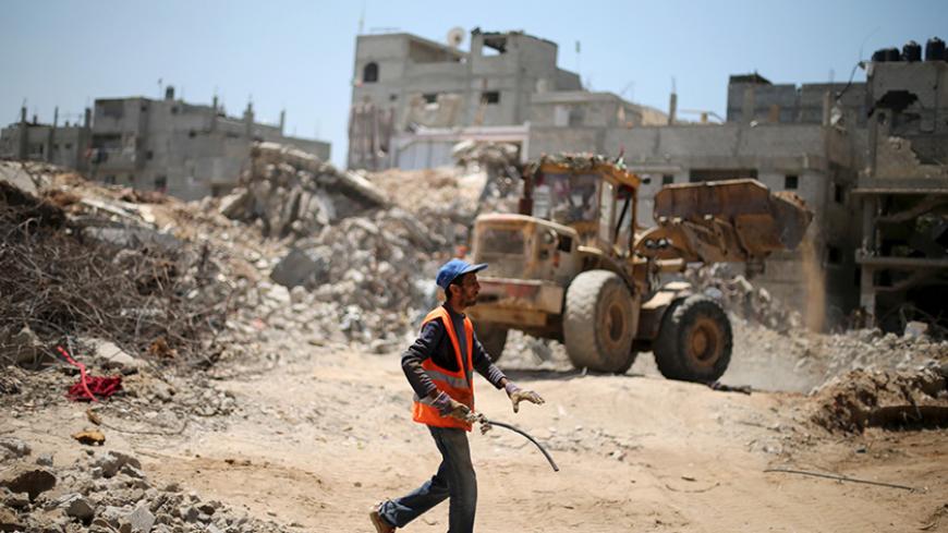 A Palestinian worker salvages metal as others clear the rubble of houses that witnesses said were destroyed by Israeli shelling during a 50-day war last summer, in the east of Gaza City May 6, 2015. In recent weeks, a flurry of envoys has beaten a path to Gaza's door: representatives from Qatar, Turkey, the United Nations, the European Union and former U.S. president Jimmy Carter have all visited or tried to visit. The impact of the stand-off is widespread, but in two areas it is particularly problematic: i