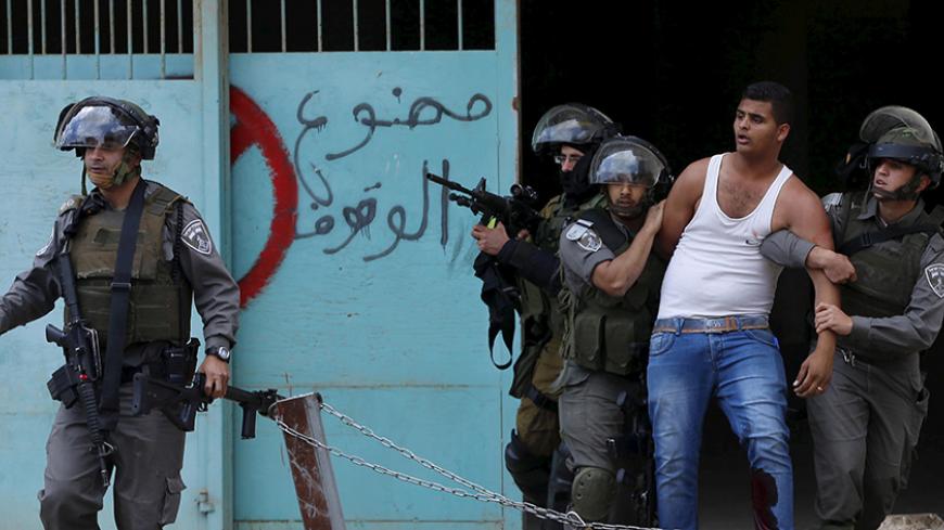 Israeli border policemen detain a wounded Palestinian protester who witnesses said was shot by the troops during clashes following a rally ahead of the Nakba day in the West Bank city of Bethlehem May 14, 2015. Palestinians mark "Nakba" (Catastrophe) on May 15 to commemorate the expulsion or fleeing of some 700,000 Palestinians from their homes in the war that led to the founding of Israel in 1948. REUTERS/Ammar Awad      TPX IMAGES OF THE DAY      - RTX1CYIX
