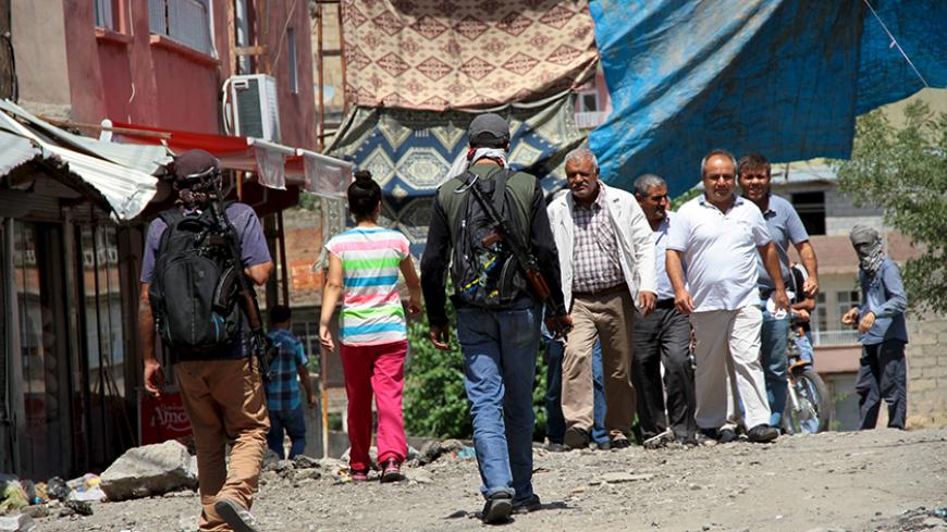 Armed members of YDG-H (back facing), youth wing of the outlawed Kurdistan Workers Party (PKK), stroll at a street in Silvan, near the southeastern city of Diyarbakir, Turkey, August 17, 2015. The PKK has attacked military targets on a near-daily basis since the Turkish government launched air strikes on rebel camps in northern Iraq on July 25, wrecking a two-year-old ceasefire. REUTERS/Sertac Kayar - RTX1OIE1