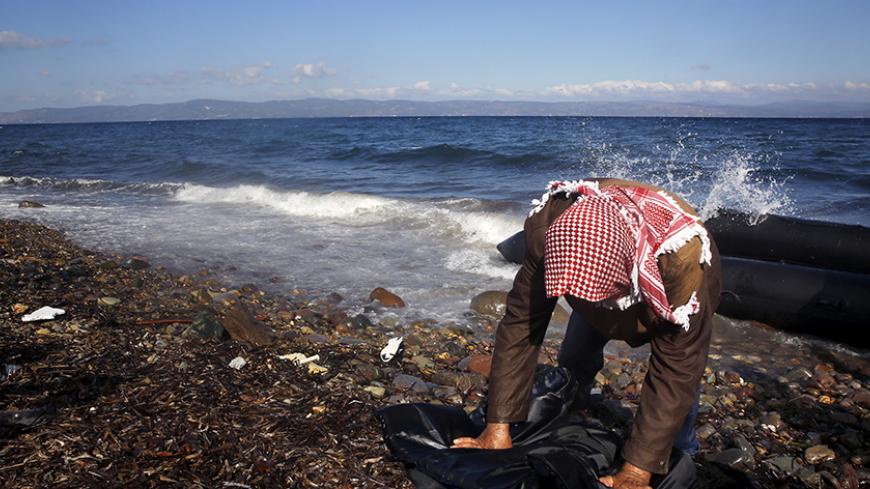 An exhausted Syrian refugee is seen moments after arriving by a raft at a beach on the Greek island of Lesbos October 25, 2015. According to United Nations over half a million refugees and migrants have arrived by sea in Greece this year and the rate of arrivals is rising, in a rush to beat the onset of freezing winter.  REUTERS/Yannis Behrakis - RTX1T45I
