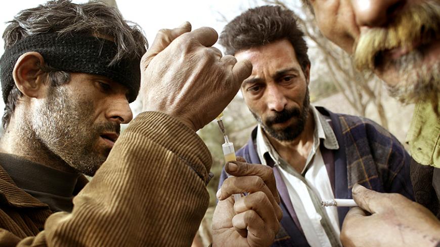 Iranian drug addicts prepare heroin for injection near the Zeytoun (olive) drug rehabilitation center in south Tehran February 23, 2004.The Zeytoun center is run by a former addict called 'Forouhar' who weaned himself off drugs in the [United States]. Senior police officers have recently estimated that the Islamic Republic has some two million addicts and their forces struggle to contend with huge consignments of drugs smuggled over the porous border with [Afghanistan].   
? OUT 
? ONLINES - RTXMFZ9