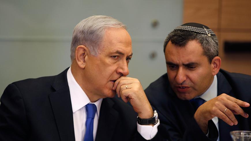 Israel's Prime Minister Benjamin Netanyahu (L) listens to Foreign Affairs and Defence committee chair Zeev Elkin during a committee meeting at parliament in Jerusalem June 2, 2014. Netanyahu warned on Sunday against any international rush to recognise a Palestinian government due to be announced under a unity pact between the Fatah and Hamas Islamist groups.REUTERS/Ronen Zvulun (JERUSALEM - Tags: POLITICS) - RTR3RRU6