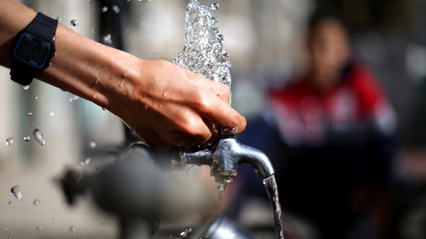 A Palestinian boy squirts water from a tap in the street on March 20, 2014 as the construction of a major seawater desalination plant launched by the European Union (EU) and UNICEF began in Deir Al-Balah, in the central Gaza Strip. Only 5.8% of households in Gaza have a good water supply suitable for consumption according to a statement released by the Palestinian Central Beureau of statistics on the occasion of World water day.  AFP PHOTO/MOHAMMED ABED        (Photo credit should read MOHAMMED ABED/AFP/Get