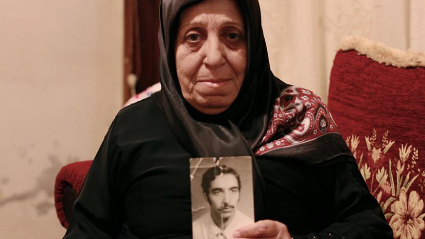 Fatima Rida holds a photo of her Missing Husband, Hussein Moalim who disappeared during Lebanon's civil war in March 1976. 