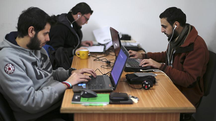 Palestinian employees process data on their laptops at Unit One in Gaza City January 15, 2015. In nine years, Gaza-based IT entrepreneur Saady Lozon and his partner Ahmed Abu Shaban have transformed their firm, Unit One, from a tiny outfit in a single room in the blockaded Gaza Strip into a successful business with clients in Europe, the United States and the Arab world. They can't leave Gaza easily, but they can develop applications for Web and mobile devices online and provide international clients with d