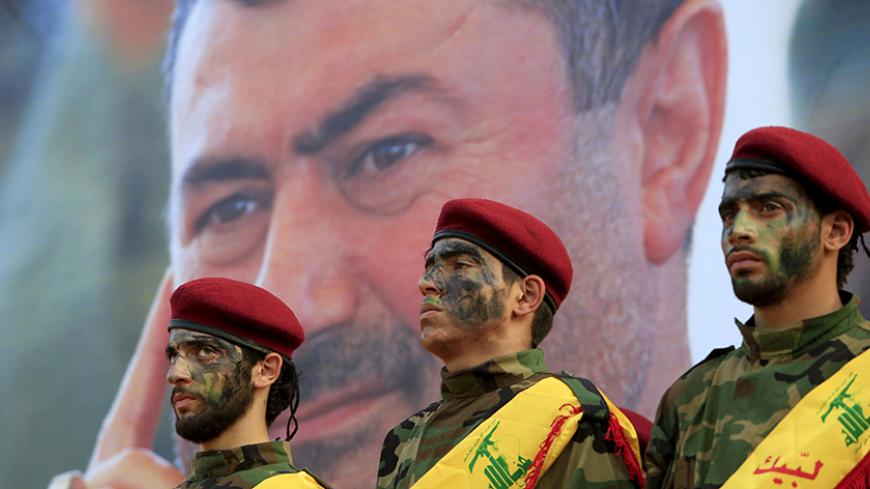 Lebanon's Hezbollah members stand at attention in front of a picture of Hassan al-Haj, one of Hezbollah's top commanders who was killed fighting alongside Syrian army forces in Idlib province, during his funeral in his hometown of al-Luwaizeh, southern Lebanon October 12, 2015. Lebanon's Hezbollah on Monday buried a commander described as the group's most important military figure to be killed in the four-year-long Syrian war. Hassan al-Haj was killed in Idlib province in northwestern Syria, where the Irani