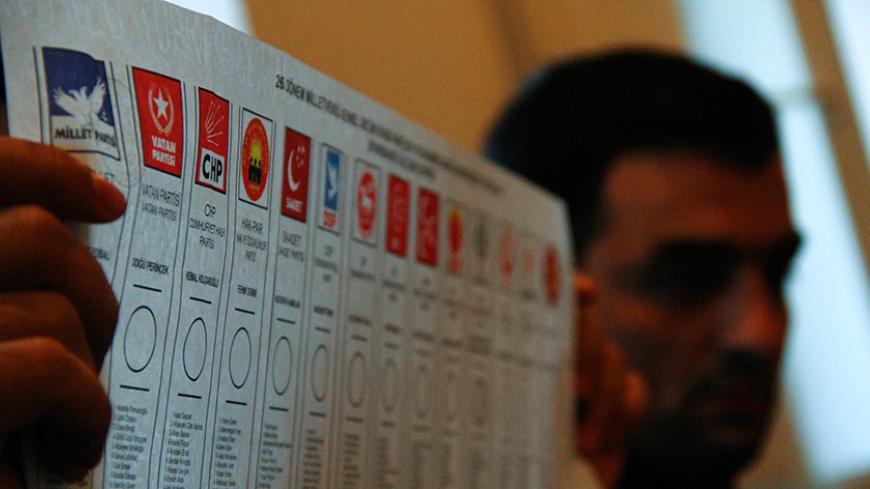 An election official holds a ballot during a count at a polling station in Diyarbakir, Turkey November 1, 2015. Turks went to the polls in a snap parliamentary election on Sunday under the shadow of mounting internal bloodshed and economic worries, a vote that could determine the trajectory of the polarised country and of President Tayyip Erdogan. The vote is the second in five months, after the AK Party founded by Erdogan lost in June the single-party governing majority it has enjoyed since first coming to