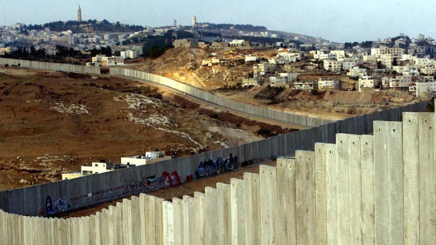 A general view of the concrete wall, part of Israel's controversial security barrier, which separates the West Bank city of Abu Dis from Jerusalem November 28, 2004. [Israel has asked French authorities to change Yasser Arafat listed place of birth on his death certificate to Cairo from Jerusalem, an Israeli official said Sunday.] - RTXN3CG