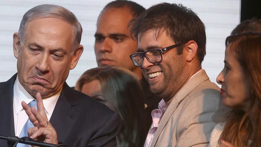 A picture dated on March 18, 2015 shows Israel's deputy parliament speaker, lawmaker Oren Hazan (2nd R) standing next to Israeli Prime Minister Benjamin Netanyahu (L) as they wait for exit polls in Israel's parliamentary elections in Tel Aviv. Hazan, has said he will sue privately owned Channel 2 over a report alleging his involvement in pimping and drugs. Channel 2 ran an investigative report on June 8, 2015 alleging that Hazan, who used to run a casino in Bulgaria, had arranged to provide casino-goers wit