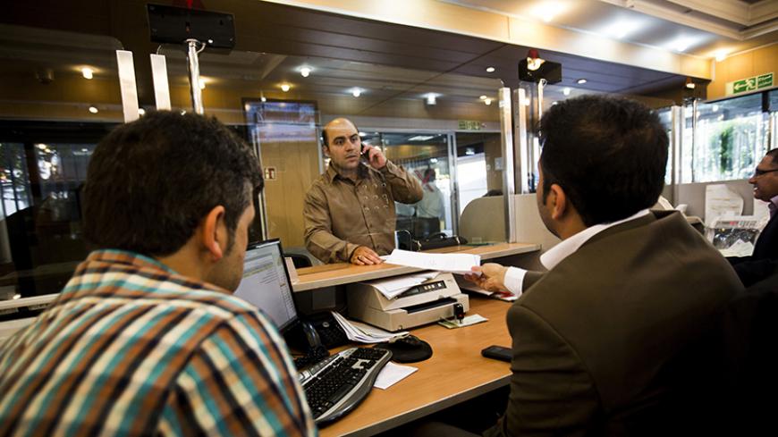 An Iranian customer speaks with a bank clerk at the Export Development Bank of Iran in the capital Tehran on July 27, 2015. Iran's central bank chief said that Iran has assets of $29 billion in overseas banks that could be unlocked under a nuclear deal struck on July 14, far less than reported estimates of over $100 billion. AFP PHOTO / BEHROUZ MEHRI        (Photo credit should read BEHROUZ MEHRI/AFP/Getty Images)