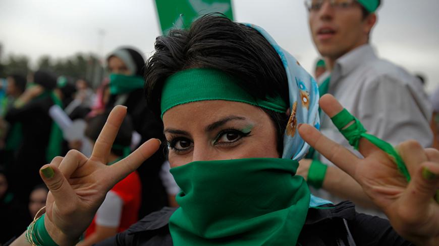 A supporter of Iran's former Prime Minister Mirhossein Mousavi, who is a candidate in the upcoming presidential elections, gestures during a rally in Tehran on the last day of campaigning June 10, 2009. Green is the campaign colour of Mousavi. REUTERS/Ahmed Jadallah (IRAN POLITICS ELECTIONS) - RTR24IVK