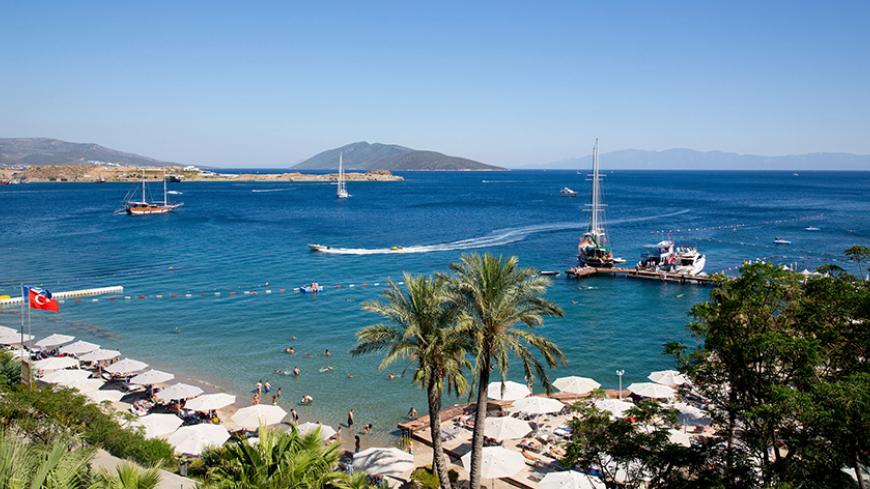 Holidaymakers rest at a beach in the resort town of Bodrum July 14, 2014. As families splash in the sea and lounge in the sun, thoughts of politics and civic duty are a world away for most Turks holidaying on the Aegean and Mediterranean coasts. Only the most committed opponents of Prime Minister Tayyip Erdogan leave the beach to queue in a sweltering council building nearby to register to vote in next month's presidential election to prevent what they see as the country's slide towards authoritarianism. Th