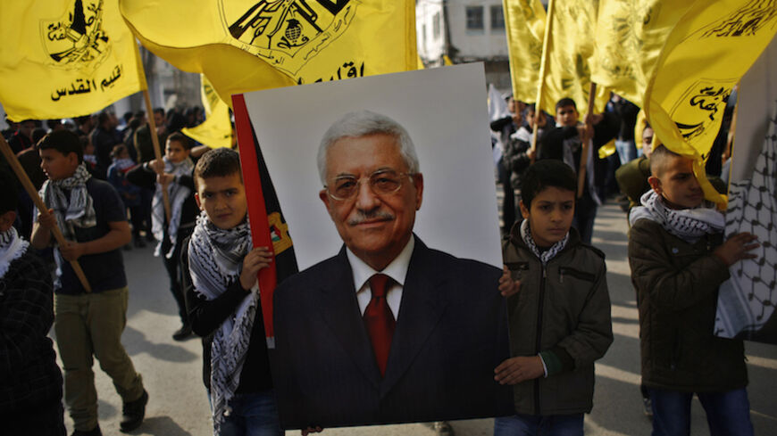 Palestinian boys carry a poster depicting Palestinian President Mahmoud Abbas during a rally marking the 50th anniversary of the founding of the Fatah movement, at Qalandia refugee camp near the West Bank city of Ramallah January 1, 2015.  REUTERS/Mohamad Torokman (WEST BANK - Tags: ANNIVERSARY CIVIL UNREST POLITICS) - RTR4JTEA