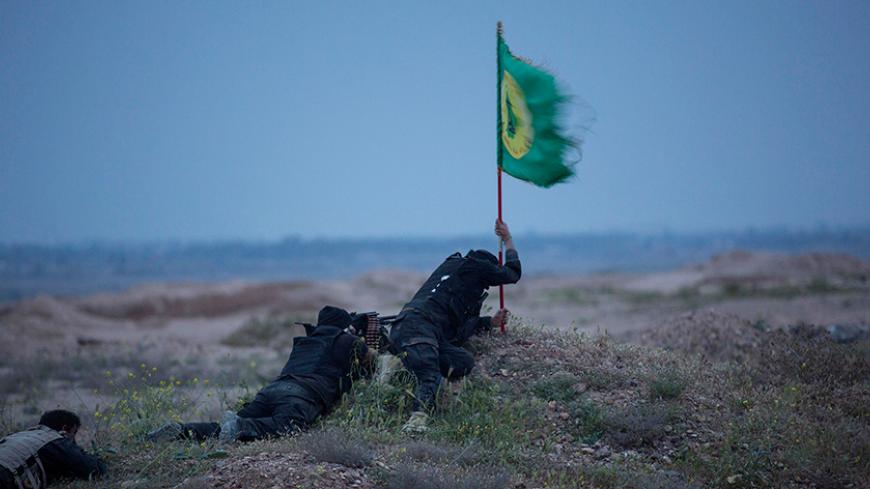 Shi'ite fighters, known as Hashid Shaabi, clash with Islamic State militants, as one tries to put a Shi'ite flag in the ground, in northern Tikrit, March 12, 2015. Iraqi security forces and mainly Shi'ite militia fought Islamic State fighters in Tikrit on Thursday, a day after they pushed into Saddam Hussein's home city in their biggest offensive yet against the militants. Picture taken March 12, 2015.    REUTERS/Stringer (IRAQ - Tags: POLITICS CIVIL UNREST CONFLICT) - RTR4T6WJ