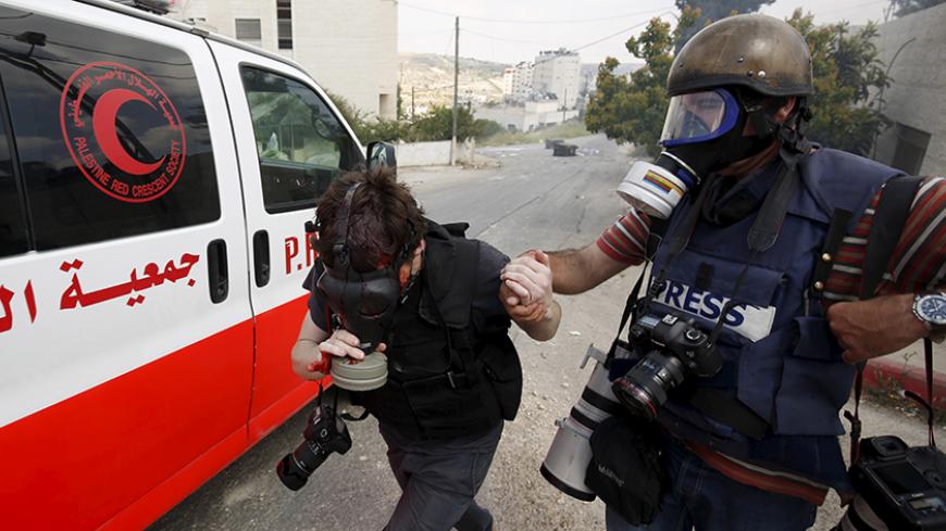 A photojournalist is evacuated after he was wounded during clashes between Israeli troops and Palestinian protesters following a rally marking Nakba Day near Israel's Ofer Prison near the West Bank city of Ramallah May 15, 2015. Palestinians mark "Nakba" (Catastrophe) on Friday to commemorate the expulsion or fleeing of some 700,000 Palestinians from their homes in the war that led to the founding of Israel in 1948. REUTERS/Mohamad Torokman
 - RTX1D4FV