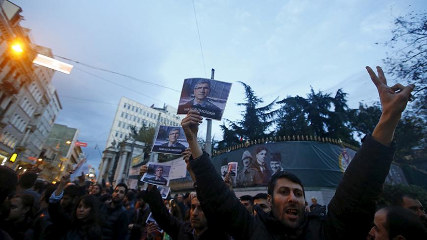 A demonstrator holds a picture of Bar Association President Tahir Elci during a protest in Istanbul, Turkey, November 28, 2015. An unidentified gunman on Saturday killed a top Kurdish lawyer who had been criticised in Turkey for saying the banned Kurdistan Workers Party (PKK) was not a terrorist organisation. Witnesses said Bar Association President Tahir Elci was shot in the head after making a statement to the media in Diyarbakir, the largest city in Turkey's troubled, mainly Kurdish southeast.  REUTERS/O