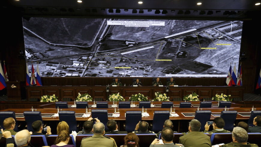 Defence ministry officials sit under screens with satellite images on display during a briefing in Moscow, Russia, December 2, 2015. Russia's defence ministry said on Wednesday it had proof that Turkish President Tayyip Erdogan and his family were benefiting from the illegal smuggling of oil from Islamic State-held territory in Syria and Iraq.  REUTERS/Sergei Karpukhin - RTX1WTWJ
