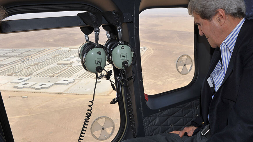 U.S. Secretary of State John Kerry looks out of a helicopter's window at Mrigeb al-Fuhud refugee camp July 18, 2013. Kerry spent about 40 minutes with half a dozen refugees who vented their frustration at the international community's failure to end Syria's more than two-year-old civil war, while visiting the Zaatari refugee camp that holds roughly 115,000 Syrian refugees in Jordan about 12 km (eight miles) from the Syrian border. REUTERS/Mandel Ngan/Pool (JORDAN - Tags: POLITICS) - RTX11QF7