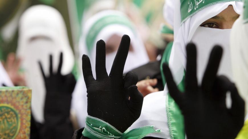 Palestinian students supporting Hamas flash three fingers to draw attention to their electoral number during an election campaign for students' council at Palestine Polytechnic University in the West Bank city of Hebron April 20, 2015. REUTERS/Mussa Qawasma      TPX IMAGES OF THE DAY      - RTX19HXV
