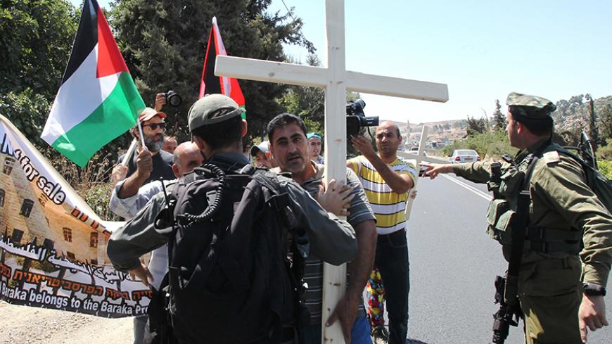 Palestinian, Israeli and Christian foreign activists confront Israeli soldiers as they walk towards Beit al-Baraka, a church compound, situated between the Al-Arub refugee camp and the city of Hebron in the occupied West Bank during a demonstration condemning the Israeli occupation, on August 15, 2015. AFP PHOTO / HAZEM BADER        (Photo credit should read HAZEM BADER/AFP/Getty Images)