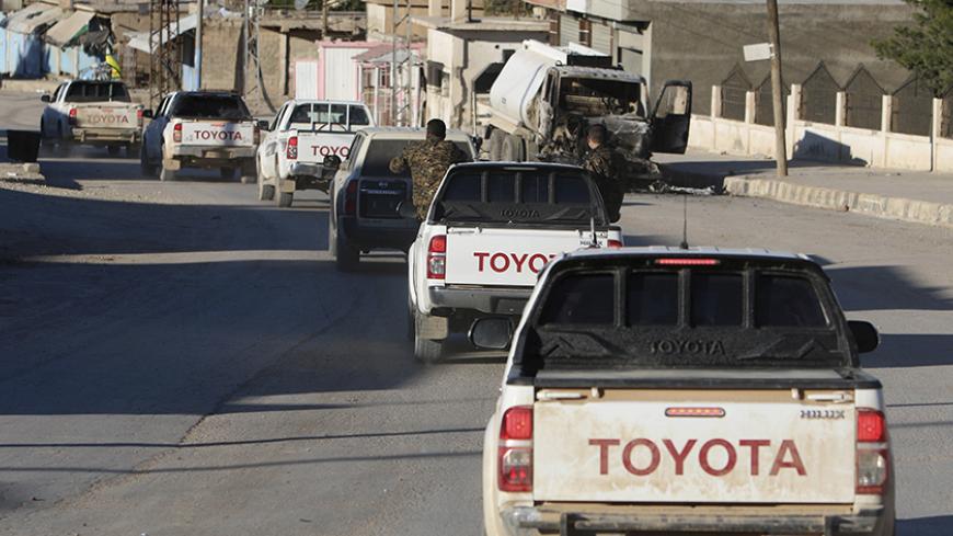Fighters from the Democratic Forces of Syria drive in a convoy as they enter the Syrian town of al Houl in Hasaka province, after they took control of it from Islamic State militants, November 14, 2015. A U.S.-backed Syrian rebel alliance on Friday captured the town of al Houl in Hasaka province, which had been held by Islamic State militants, a spokesman for the Kurdish fighters, part of the grouping, said. It was the first significant advance against IS by the Democratic Forces of Syria, which was formed 