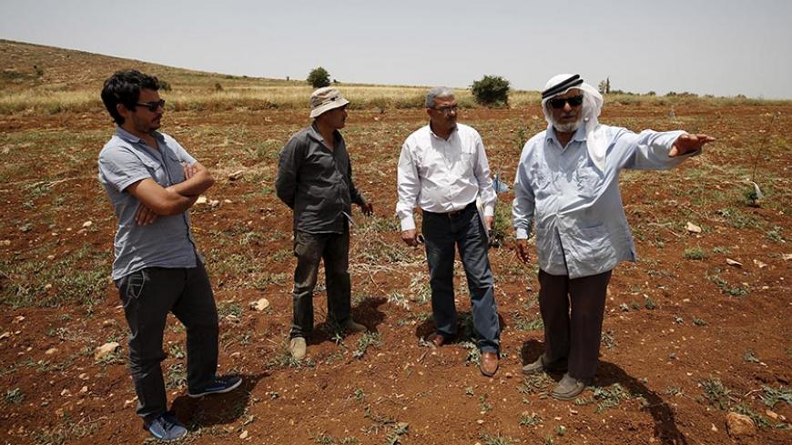 B'Tselem field researcher Iyad Hadad (2nd R) listens to a testimony from a Palestinian farmer, who said his land was damaged in an attack by Israeli settlers, in the West Bank village of Turmus Aya near Ramallah June 8, 2015. B'Tselem is an Israeli NGO that has long been a bane of the government, tirelessly flagging human rights abuses by Israel's military in the Palestinian territories. Set up by a group of academics, lawyers, journalists and politicians more than 25 years ago, the organisation - whose nam