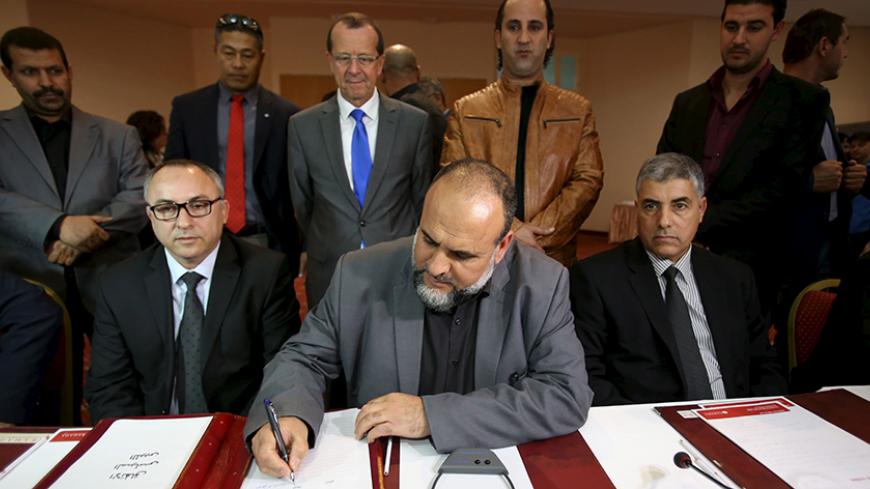 United Nations Special Representative and Head of the U.N. Support Mission in Libya Martin Kobler (C, top) looks on as representatives of Libyan municipalities sign documents to support Libya's new national government during a meeting in Tunis, Tunisia, December 21, 2015. REUTERS/Zoubeir Souissi - RTX1ZO40