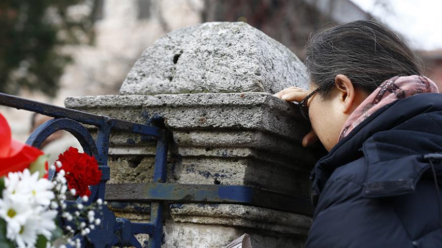 A person pays their respects at the Obelisk of Theodosius, the scene of the suicide bomb attack, at Sultanahmet square in Istanbul, Turkey January 13, 2016. Turkish authorities detained three Russian nationals suspected of links with Islamic State following a suicide bomb attack in Istanbul that killed 10 tourists, media reports said on Wednesday. A suicide bomber thought to have crossed recently from Syria killed nine German and one Peruvian tourists on Tuesday in Istanbul's historic Sultanahmet Square, a 