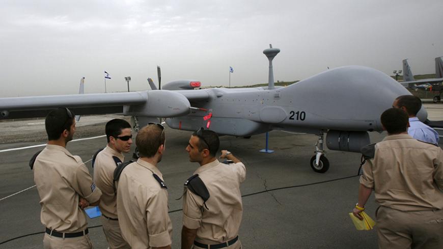 Israeli soldiers look at an IAI Eitan, also known as the Heron TP, surveillance unmanned air vehicle (UAV) on display at Tel Nof Air Force Base near Tel Aviv February 21, 2010. An Israeli air force officer said the Israeli-made drone is larger than any other drone and can fly at higher altitudes, while carrying more weight including advanced technological systems. The officer said the drone's main advantage was its longer flying time, estimated at 20 hours. REUTERS/Gil Cohen Magen (ISRAEL - Tags: TRANSPORT 