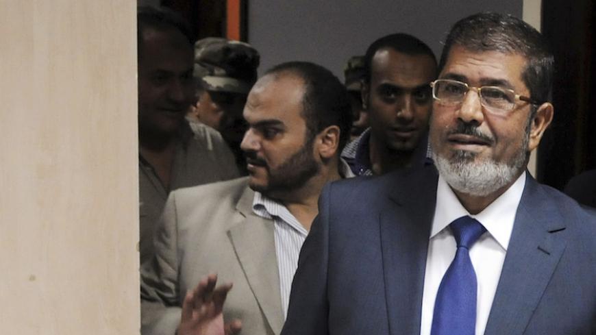 Muslim Brotherhood's president-elect Mohamed Morsy (R) arrives at the Egyptian Television headquarters for his first televised address to the nation in Cairo June 24, 2012. Morsy's victory in Egypt's presidential election takes the Muslim Brotherhood's long power struggle with the military into a new round that will be fought inside the institutions of state themselves and may force new compromises on the Islamists. Picture taken June 24, 2012. To match Analysis EGYPT-ELECTION/STRUGGLE/   REUTERS/Stringer (