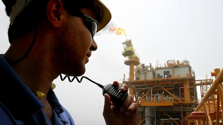 An Iranian worker speaks into a radio on an oil production platform at the Soroush oil fields in the Persian Gulf, 1,250 km (776 miles) south of the capital Tehran, July 25, 2005. Picture taken July 25, 2005. REUTERS/Raheb Homavandi  CJF/KS - RTRIU0Y