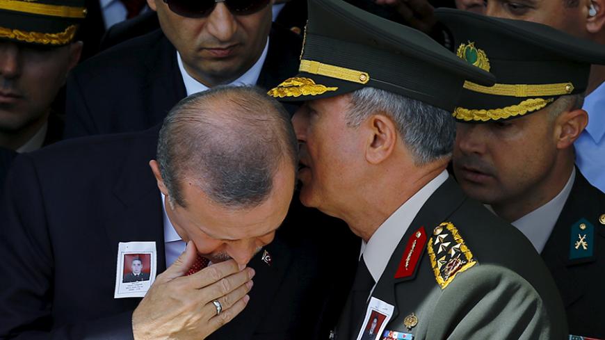 Turkey's Chief of Staff General Hulusi Akar whispers in President Tayyip Erdogan's ear during the funeral of Sergeant Okan Tasan, one of the soldiers killed during an attack on a military convoy and clashes on Sunday in the mountainous Daglica area of Hakkari province, at Kocatepe Mosque in Ankara, Turkey, September 10, 2015. Pro-Kurdish politicians, including cabinet ministers, attempted to march to a town in southeast Turkey on Thursday to protest a week-old curfew there, as their party came under fire fr