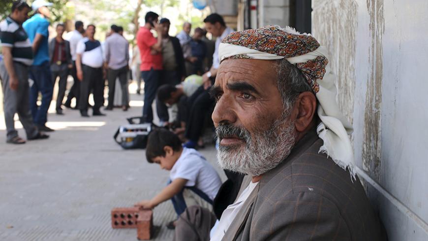 Yemenis, hoping to obtain a flight ticket back to Yemen, wait outside a branch office of Yemenia Airways after being stranded in Cairo, April 28, 2015.  At least 15 people were killed in heavy fighting between Houthi fighters and tribesmen in the oil-producing Marib province in central Yemen, tribal and medical sources said on Tuesday, as Saudi-led air strikes against the Iran-allied militia continued. REUTERS/Asmaa Waguih - RTX1AND4