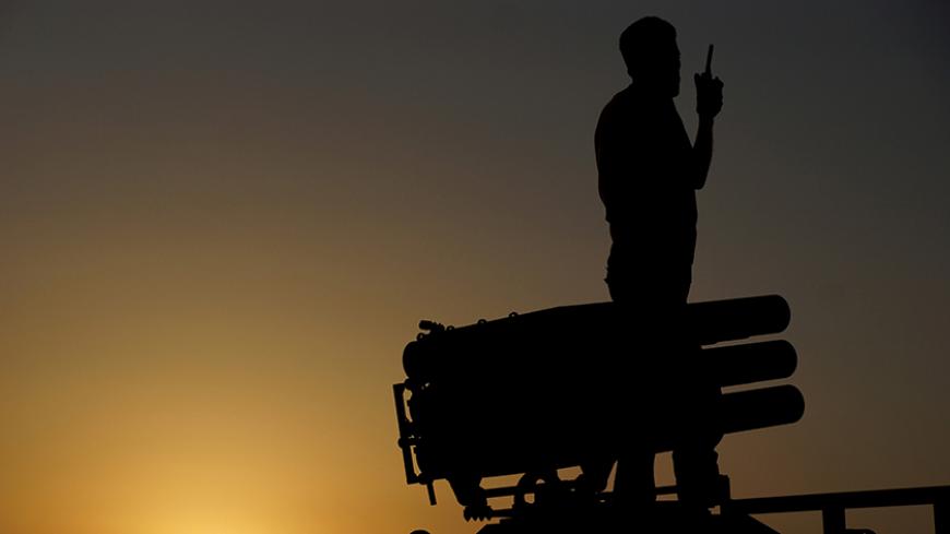A Free Syrian Army fighter talks on a walkie-talkie near a rocket launcher during what they said was preparations for an operation to strike at forces loyal to Syria's president Bashar Al-Assad located in Daraa, July 27, 2015. Picture take July 27, 2015. REUTERS/Alaa Al-Faqir
 - RTX1M47P