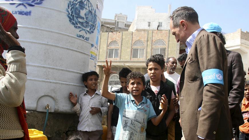 UNICEF's representative in Yemen, Julien Harneis, listens to a boy during a visit to Yemen's southwestern city of Taiz January 21, 2016. REUTERS/Anees Mahyoub - RTX23EIY