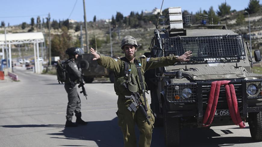 An Israeli soldier gestures near the scene of a shooting attack at an Israeli military checkpoint near the West Bank city of Ramallah January 31, 2016. REUTERS/Mohamad Torokman  - RTX24S7Z