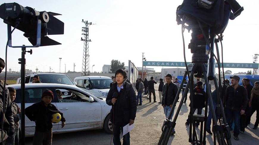 A Japanese journalist reports at the Akcakale border crossing in Sanliurfa province, southeastern Turkey, where Islamic State militants control the Syrian side of the gate, January 29, 2015. An audio message purportedly from a Japanese journalist held by Islamic State militants said Jordanian air force pilot Muath al-Kasaesbeh, who also captured by the group would be killed unless Sajida al-Rishawi, a woman jailed in Jordan, was released by sunset on Thursday. The message postponed a previous deadline set o