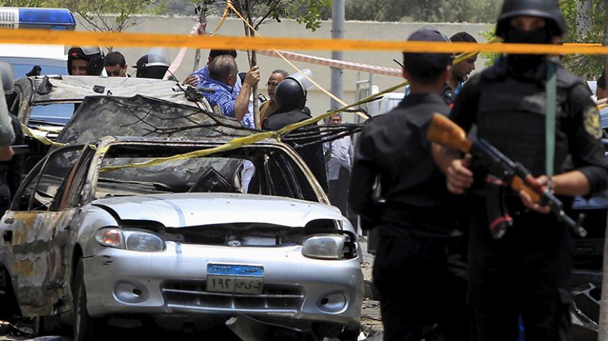 Policemen secure the site of a car bomb attack on the convoy of Egyptian public prosecutor Hisham Barakat near his house at Heliopolis district in Cairo, Egypt, June 29, 2015. Barakat died from wounds sustained in a bomb attack on Monday that had targeted his convoy in Cairo, state news agency MENA said. REUTERS/Mohamed Abd El Ghany - RTX1I9OL