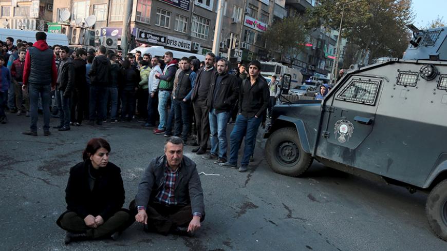 Sibel Yigitalp (L), a parliamentarian from the the pro-Kurdish Peoples' Democratic Party (HDP), and Abdullah Akengin, a former local mayor, holds a sit-in protest against the curfew in Sur district, in the southeastern city of Diyarbakir, Turkey, December 18, 2015. REUTERS/Sertac Kayar - RTX1ZABH