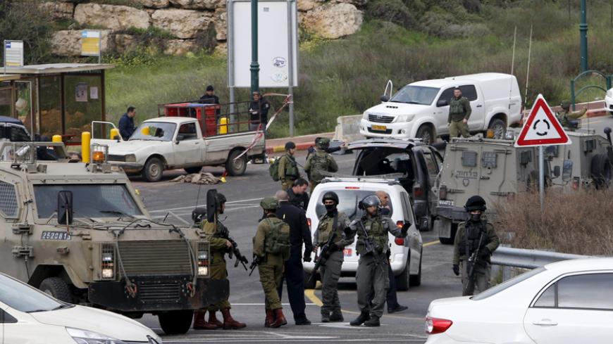 Israeli security forces gather near the scene of what the Israeli military said were back-to-back gun and car-ramming attacks by Palestinians, near the Jewish settlement of Kiryat Arba near the West Bank city of Hebron March 14, 2016. Three Palestinians carried out back-to-back gun and car-ramming attacks on Israelis near a Jewish settlement in the occupied West Bank on Monday and were shot dead by the army, it said. REUTERS/Mussa Qawasma - RTX290TP