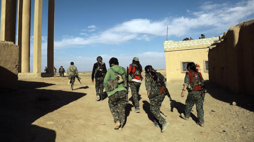 Fighters from the Syrian Democratic Forces (SDF) walk past a house on the outskirts of the town of al-Shadadi in the northeastern Syrian province of Hasakeh, on February 19, 2016.
The Syrian Democratic Forces (SDF), an alliance dominated by the Kurdish People's Protection Units (YPG), seized on Friday the town of al-Shadadi, a bastion of the Islamic State group (IS) in the Hasakeh province, in northeastern Syria, according to the Syrian Observatory for Human Rights. / AFP / Delil souleiman        (Photo cre