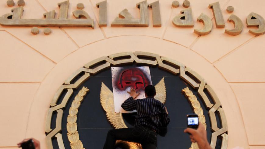 A protester spray paints a picture of the late activist Khaled Said on the emblem of the Ministry of Interior building during a demonstration against police brutality in Cairo, on the first anniversary of Said's death, June 6, 2011. Said, 28, was beaten to death by police in Alexandria in June 2010 with his body barely recognisable after he posted a video showing police officers sharing the spoils of a drugs bust, according to his family. The act of brutality galvanised further protests, in particular, the 