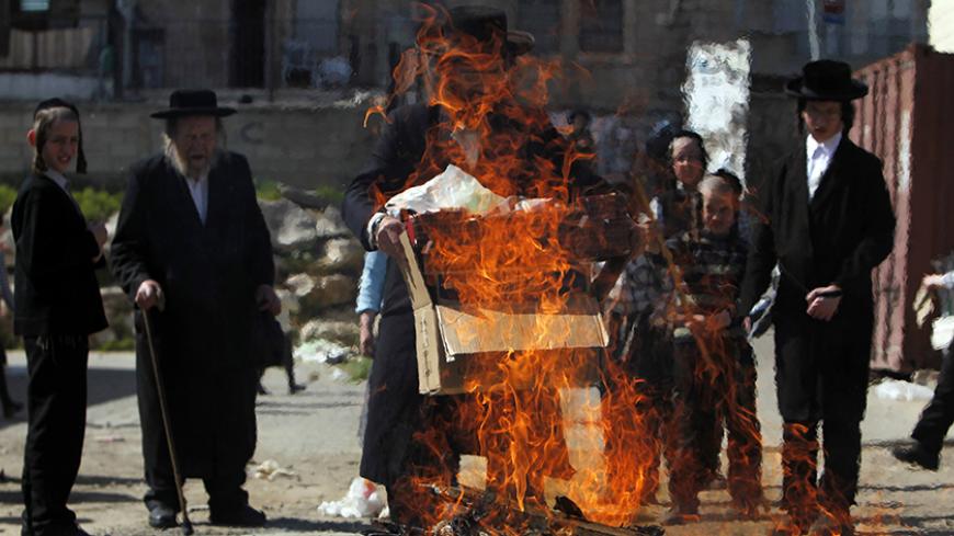 An ultra-Orthodox Jew holds a box near a fire burning leaven in the Mea Shearim neighbourhood of Jerusalem, ahead of the Jewish holiday of Passover, April 6, 2012. Passover commemorates the flight of Jews from ancient Egypt, as described in the Exodus chapter of the Bible. According to the account, the Jews did not have time to prepare leavened bread before fleeing to the promised land. REUTERS/Ronen Zvulun (JERUSALEM - Tags: RELIGION) - RTR30EPA